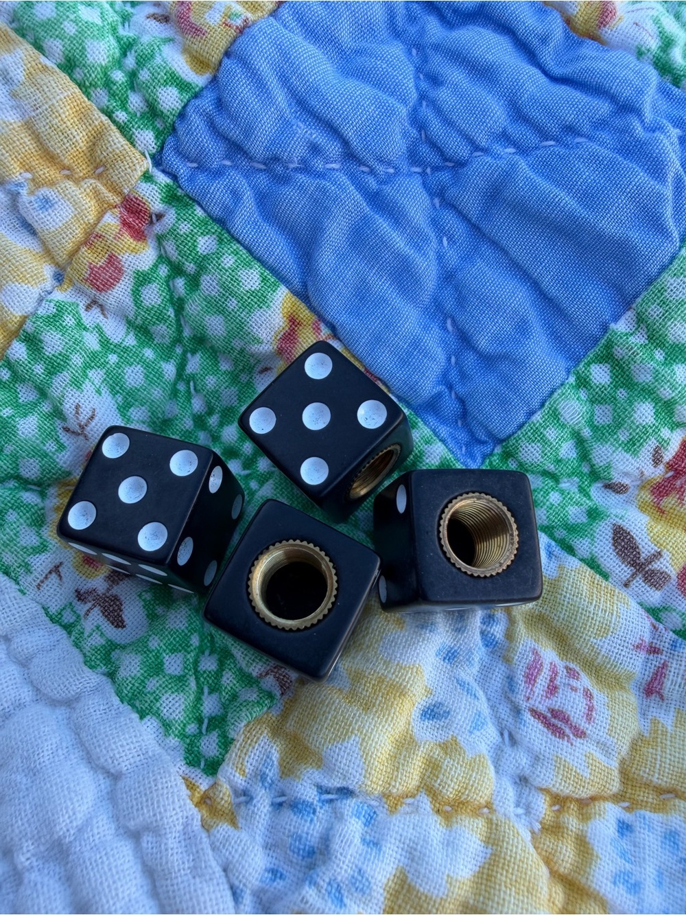 black dice-shaped tire valve stem caps with white dots and threaded brass insert